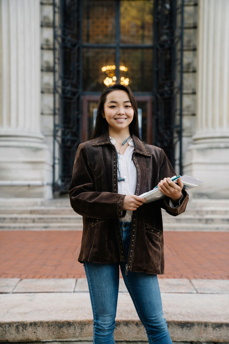 A Woman in Brown Coat Holding Documents